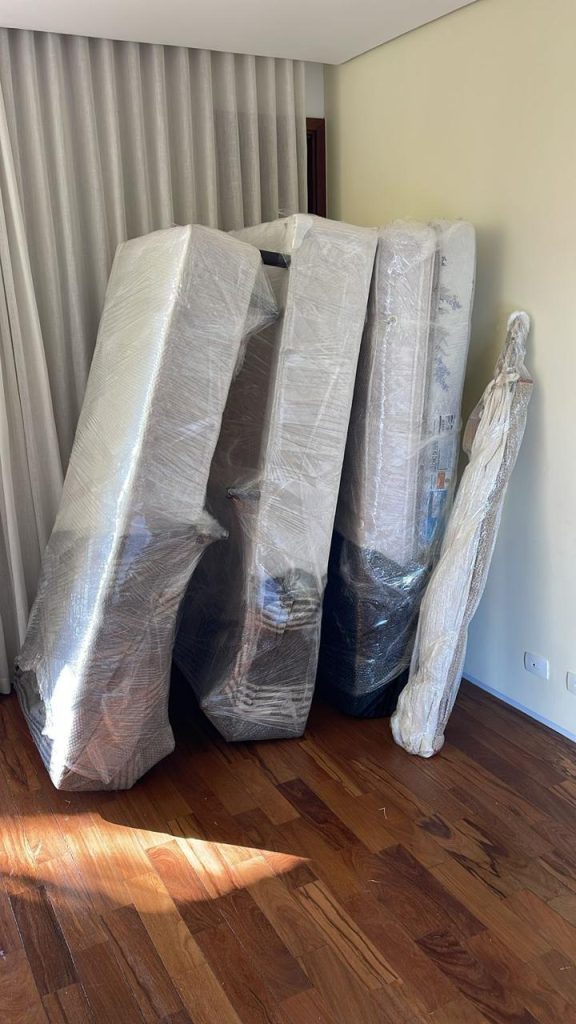 Móveis e colchões embalados e organizados em quarto antes da mudança