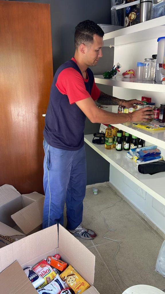 Profissional da A. Furtuoso organizando itens de prateleira em caixas